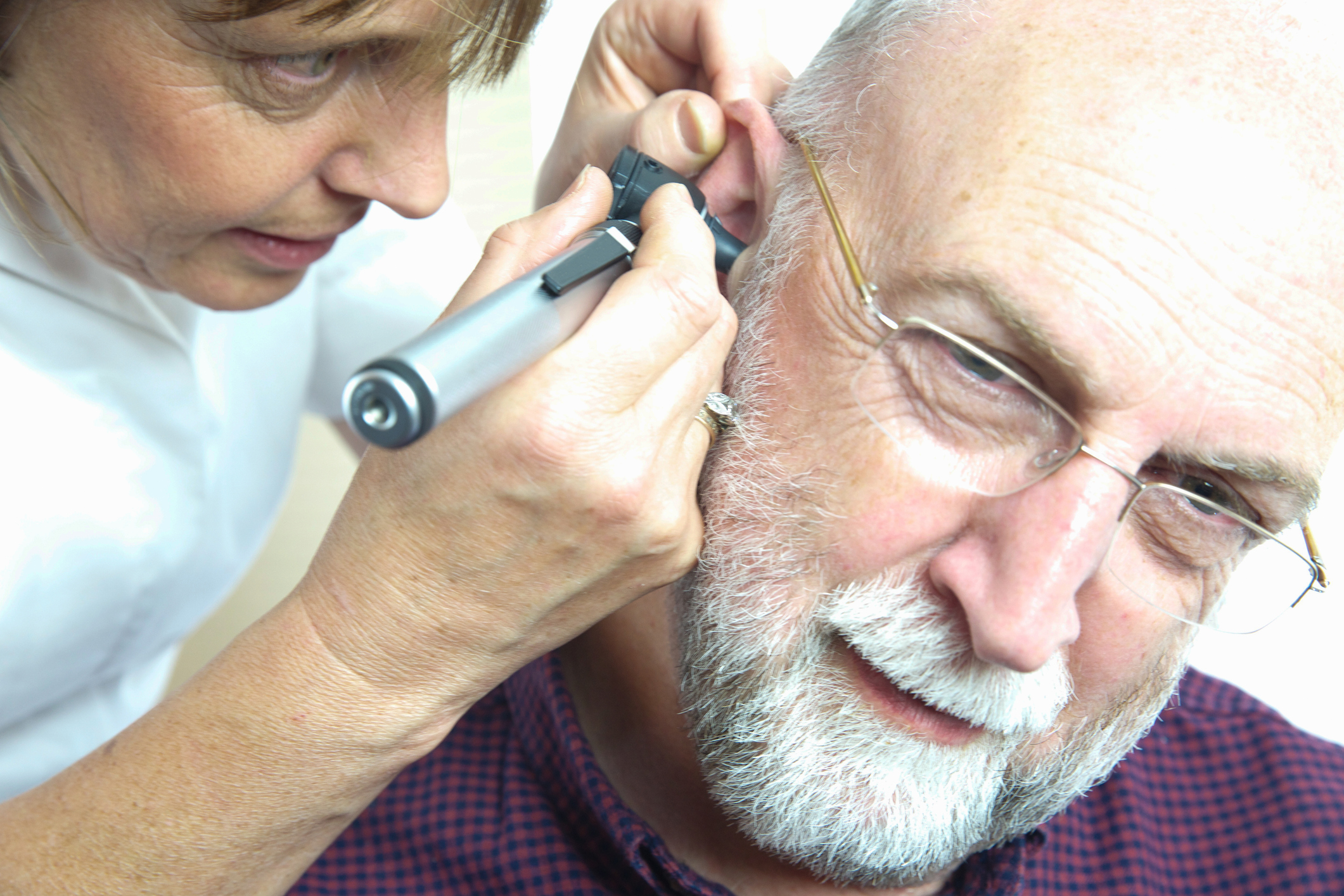 Nurse inspects patient's ear with an auroscope - the ear drum is evident from the image - all clear!